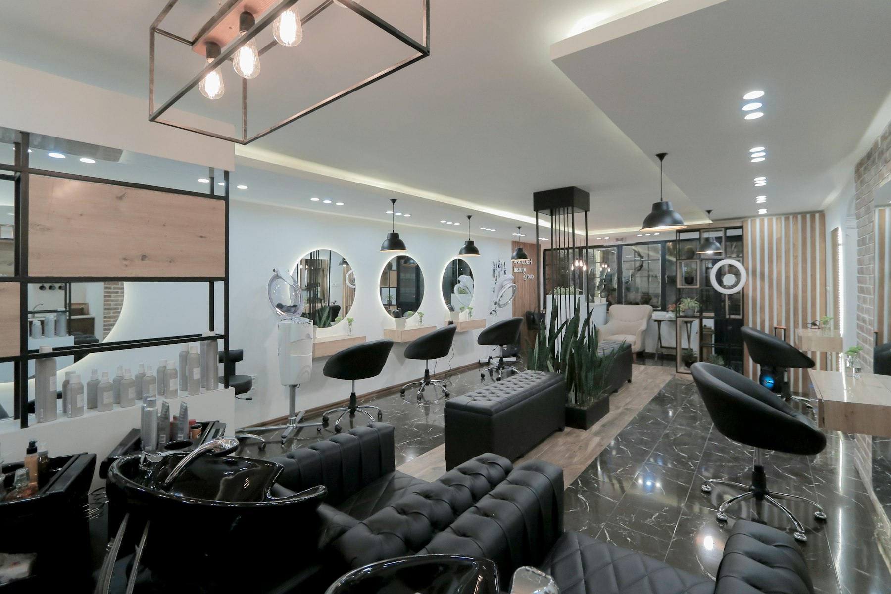 The Cutts Luxury Salon styling floor, with mirrors, marble counters and black styling chairs
