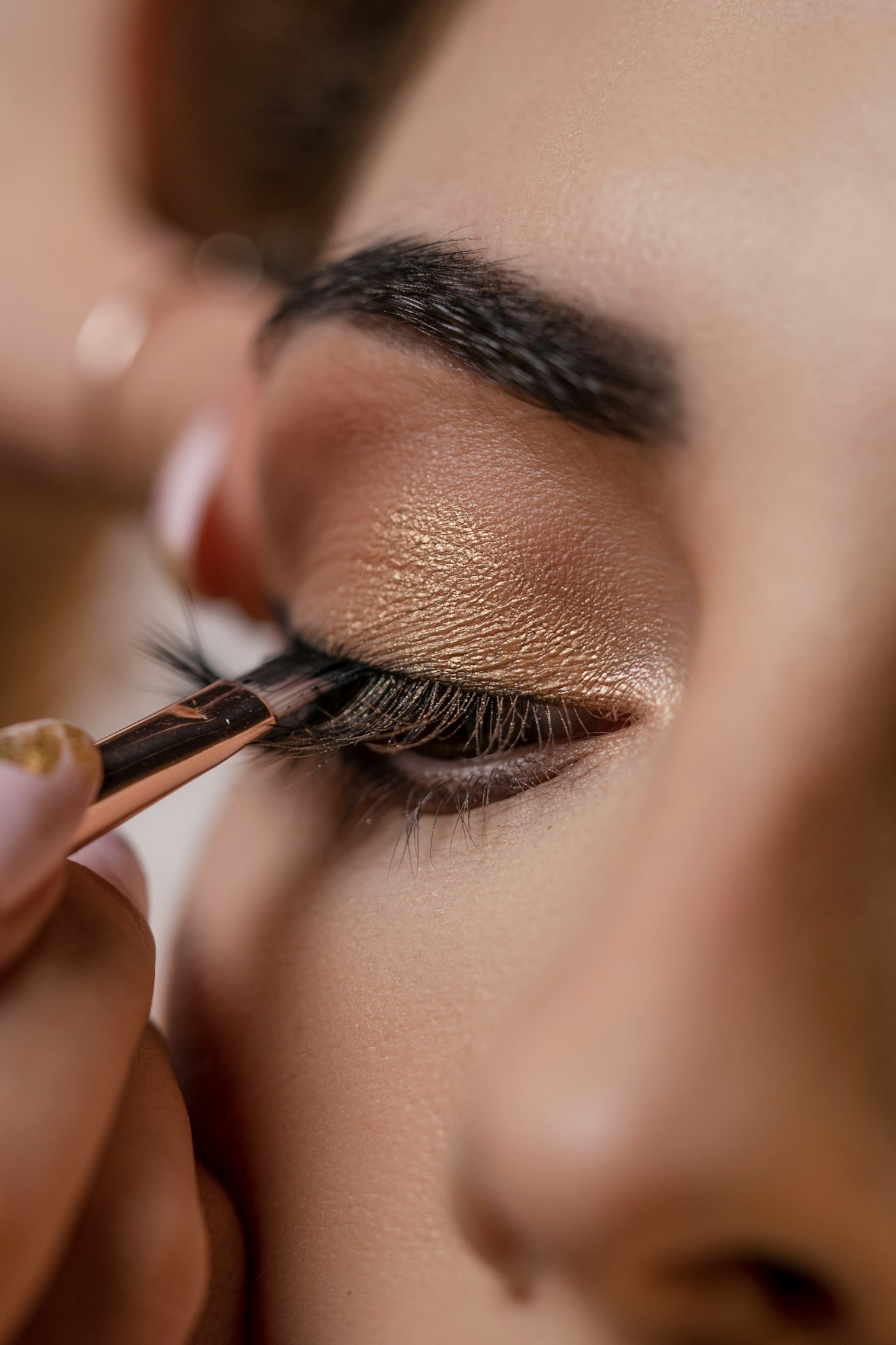 A makeup artist applying eyeshadow with a fine brush