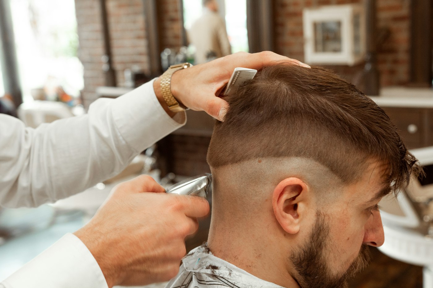 A barber finishing a men's haircut