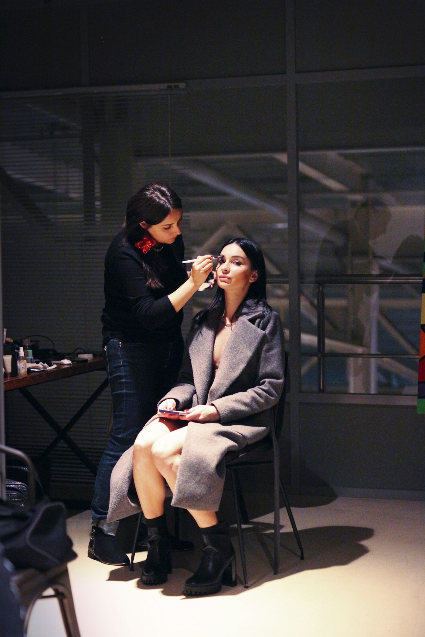 A makeup artist working on a client before an event