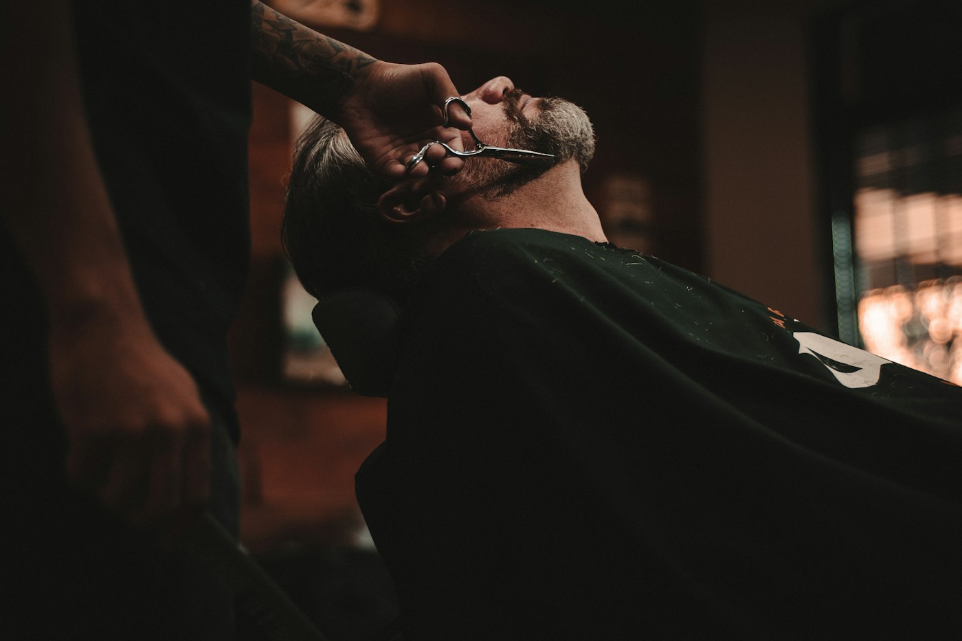 A client mid hot-towel shave in the barber chair